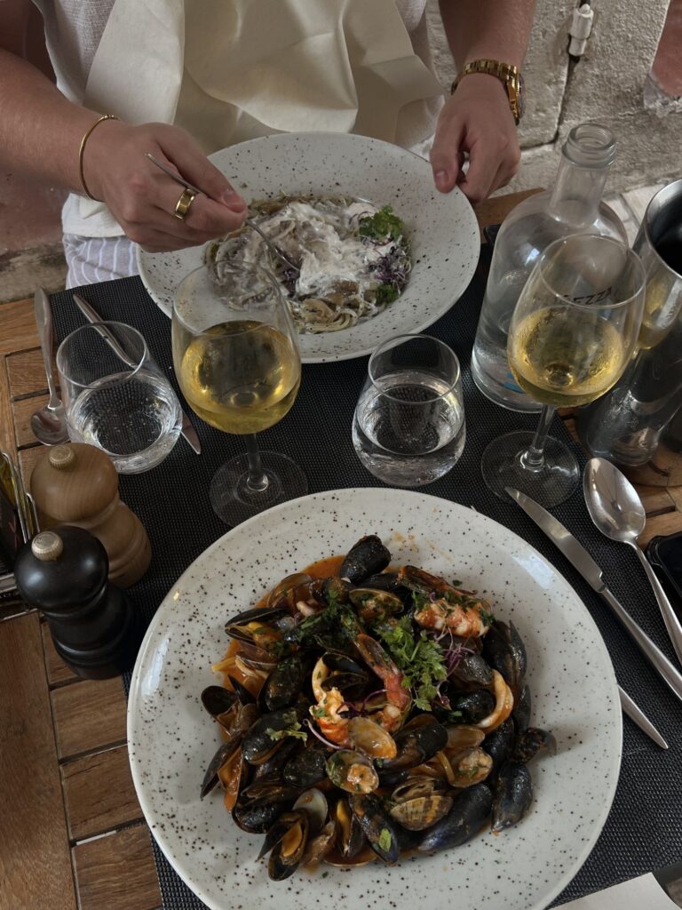 Freshly served meal on a restaurant table with drinks and cutlery.