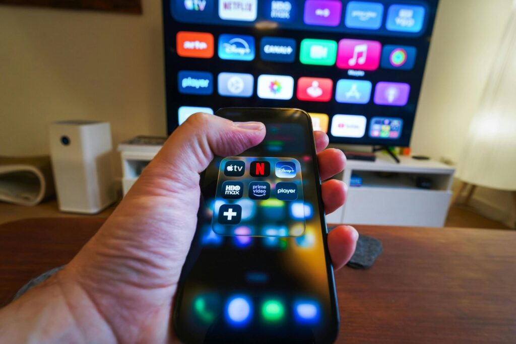 Hand holding smartphone with streaming services downloaded